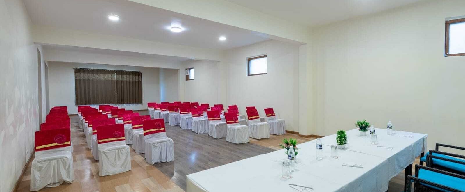 The image shows a well-lit conference room with a long table and chairs arranged for a meeting  | DLS Serenity Resort and Spa